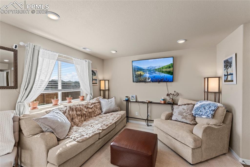 Image 15 of 37: The living room is bright and inviting, with large windows that bring in na