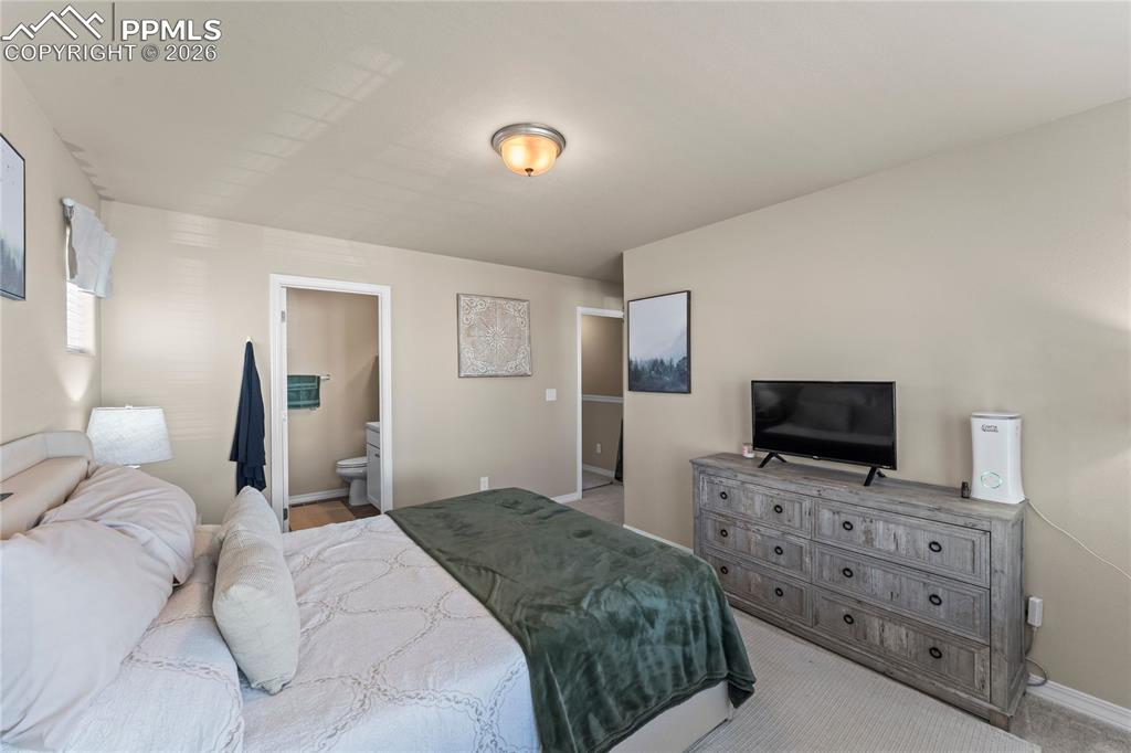 Image 21 of 37: This angle of the primary bedroom shows a comfortable layout with plenty of