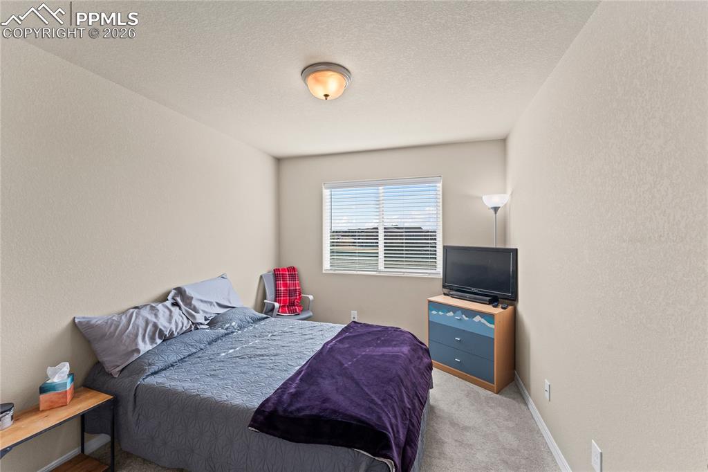 Image 25 of 37: This secondary bedroom is simple and functional with solid natural light.