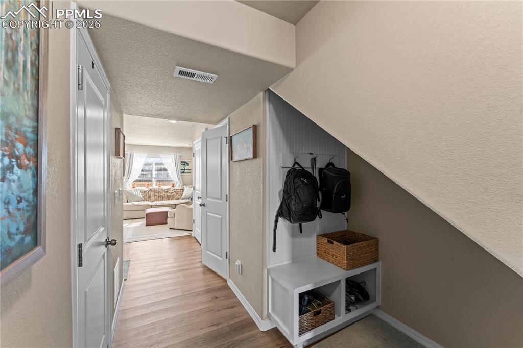 Image 5 of 37: The main level entry includes a built in drop zone under the stairs, giving