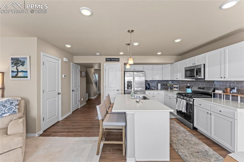 Image 7 of 37: The kitchen features a large center island with clean white cabinetry and p