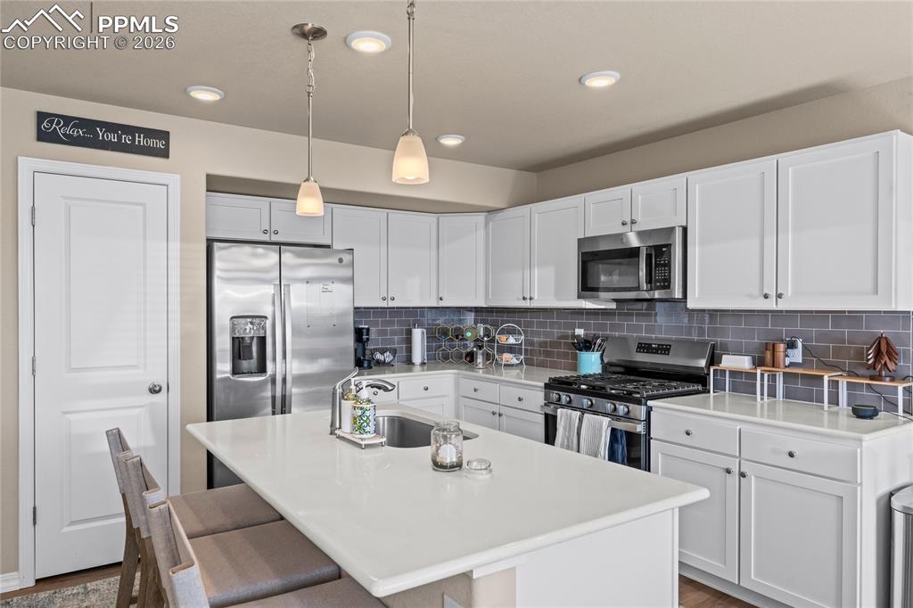Image 8 of 37: Stainless steel appliances, a gas range, and modern finishes give the kitch