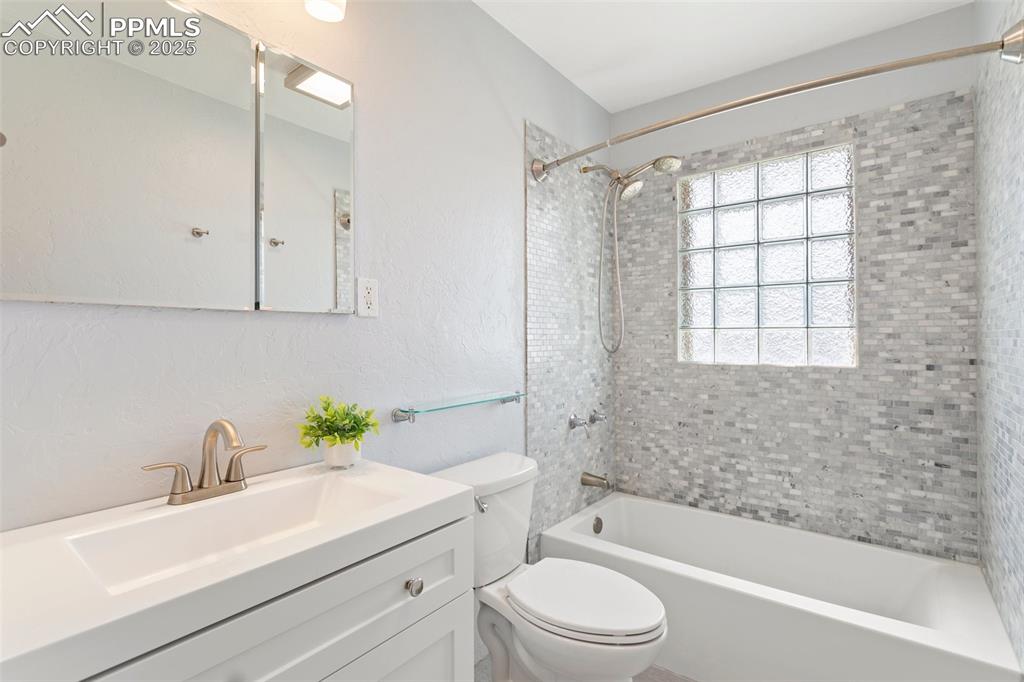 Image 22 of 37: Main level bathroom with shower / bathtub combination, vanity, and toilet