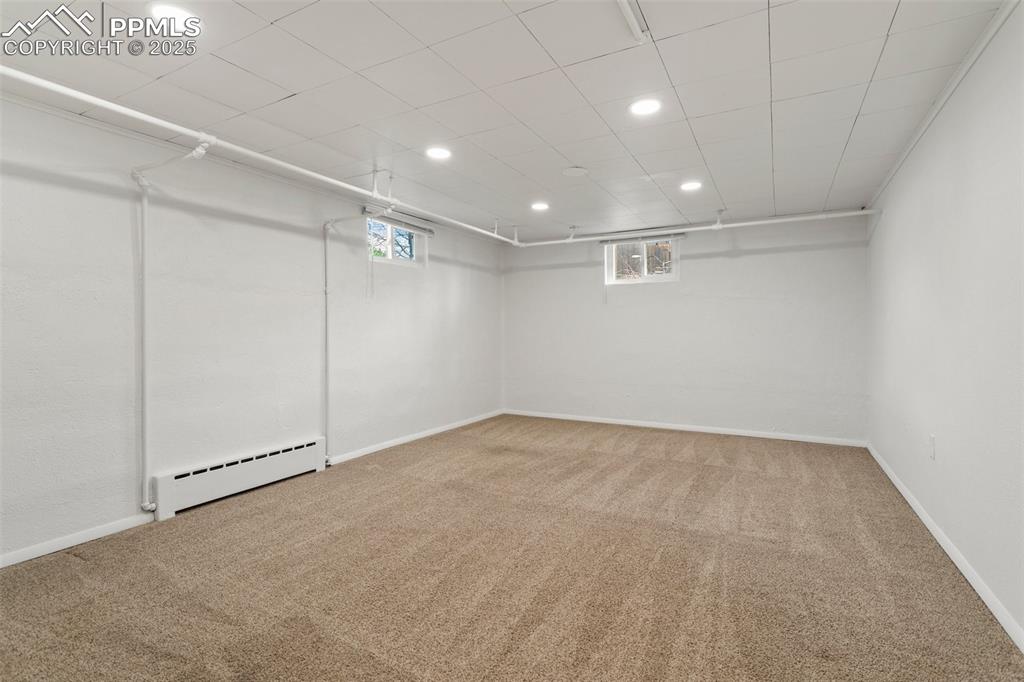 Image 25 of 37: Basement featuring a baseboard heating unit, carpet, and a healthy amount o