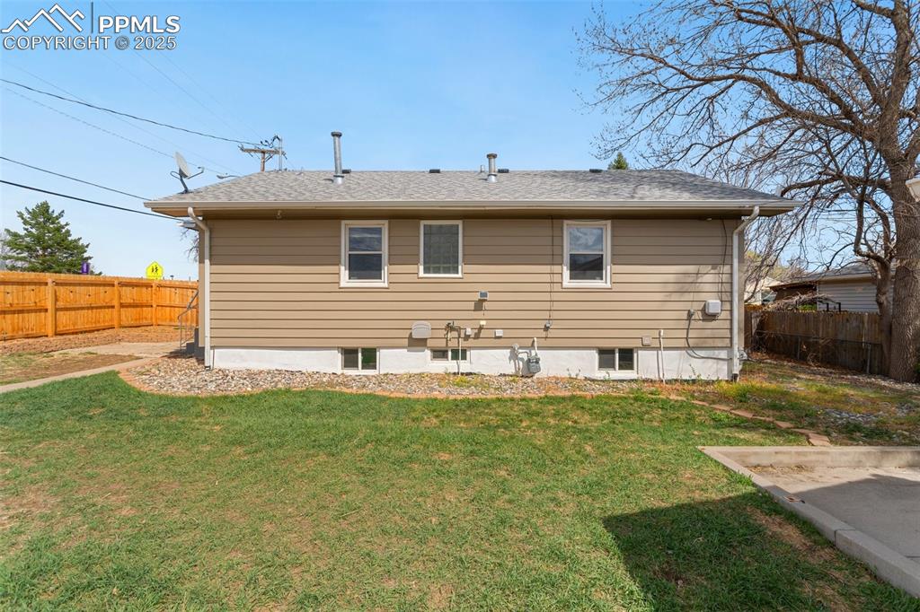 Image 37 of 37: Rear view of property with a fenced backyard, roof with shingles, and a yar