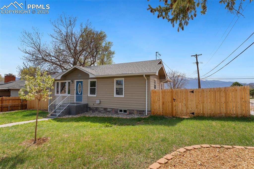 Image 8 of 37: Bungalow-style home with fence, a shingled roof, and a front lawn