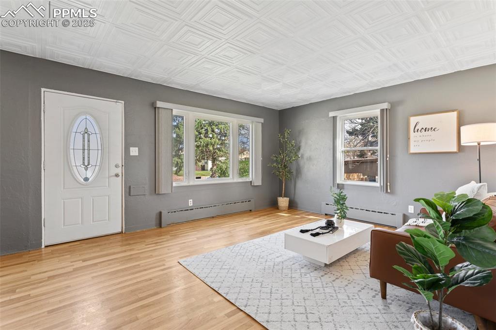 Image 9 of 37: Foyer featuring a baseboard radiator, an ornate ceiling, and wood finished