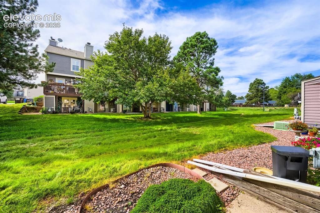 Image 22 of 23: Expansive serene green space featuring mature trees and a gravel pathway