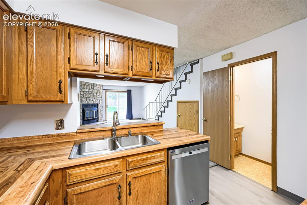 Image 5 of 23: Kitchen featuring wood-finish cabinetry, stainless steel double-basin sink,
