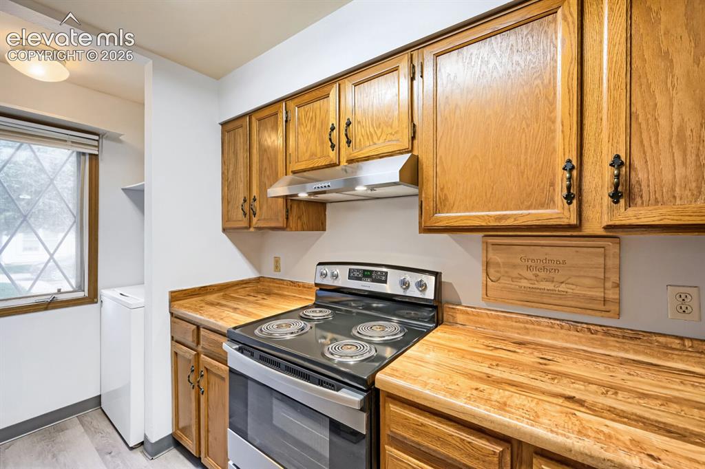 Image 6 of 23: Wood-finish cabinetry with dark hardware, wood-finish countertops, stainles