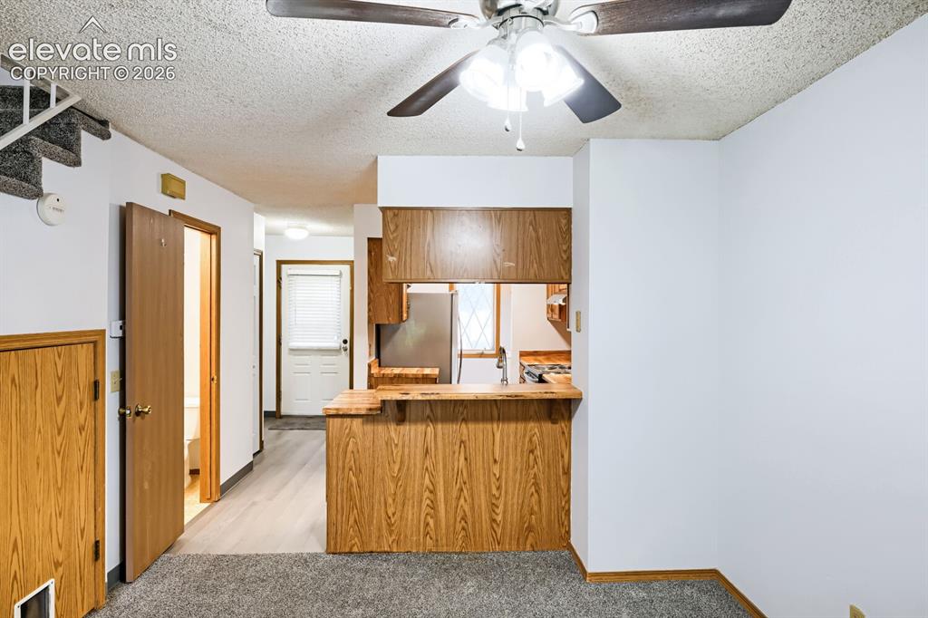 Image 8 of 23: Kitchen pass-through with wood-finish cabinetry, stainless steel appliances