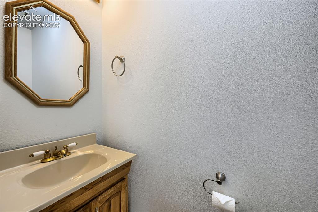 Image 9 of 23: Wood-finish vanity with an integrated sink and brass-tone faucet