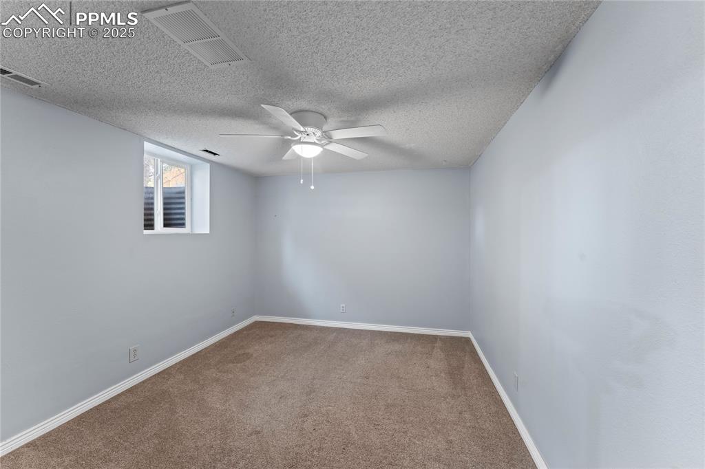 Image 18 of 36: Spare room with carpet floors, a textured ceiling, and a ceiling fan