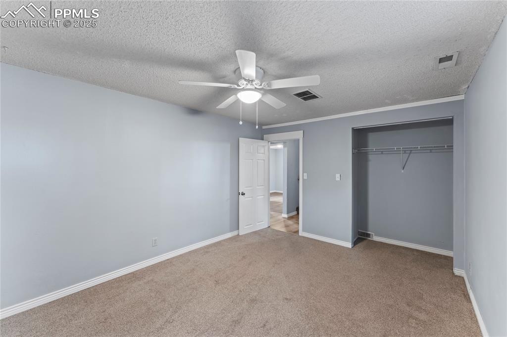 Image 19 of 36: Unfurnished bedroom featuring carpet floors, a textured ceiling, a closet, 