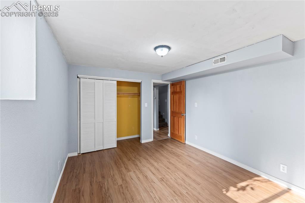 Image 23 of 36: Unfurnished bedroom featuring light wood-style flooring and a closet