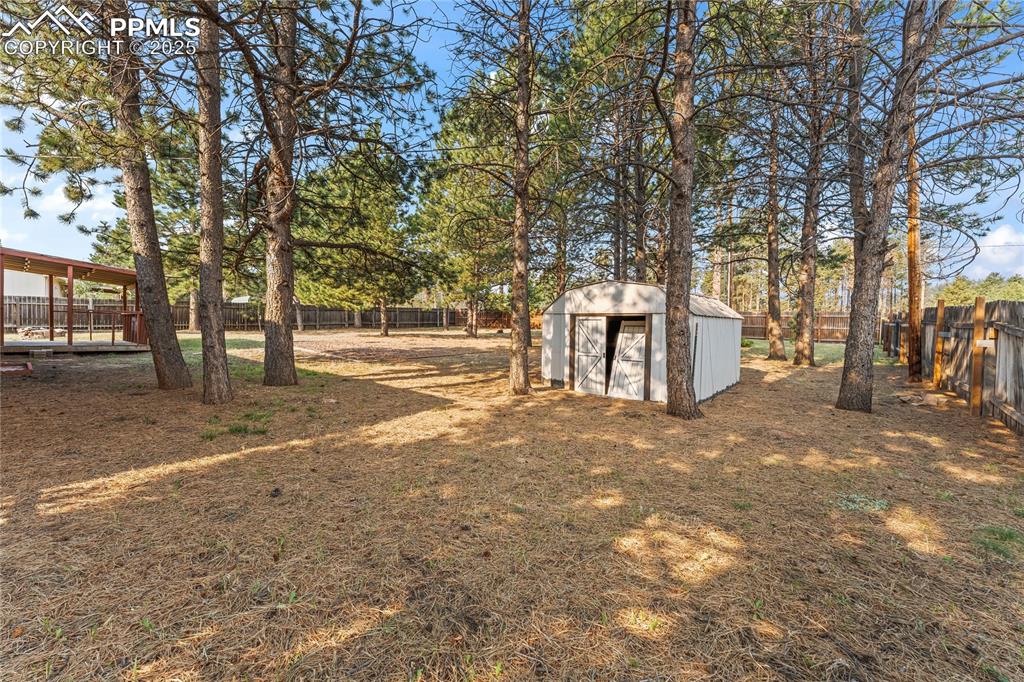 Image 29 of 36: Fenced backyard featuring a storage shed