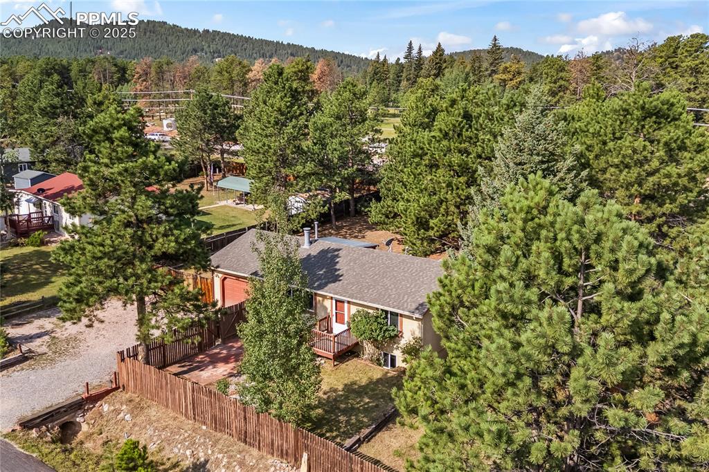 Image 4 of 36: Aerial view of property and surrounding area featuring a heavily wooded are