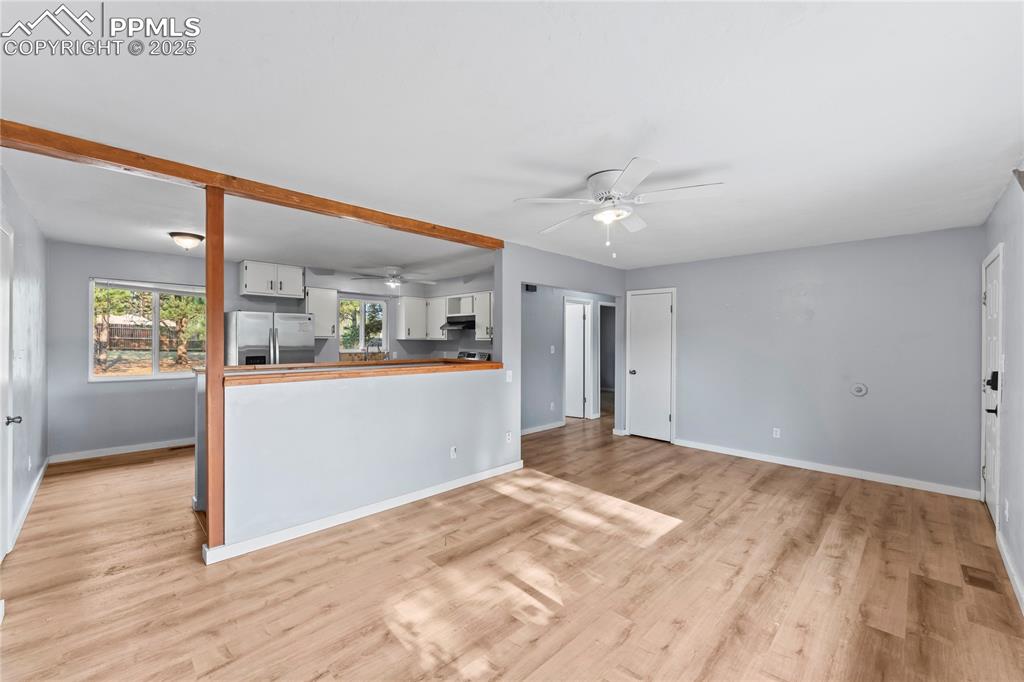 Image 6 of 36: Unfurnished living room with light wood-type flooring and ceiling fan
