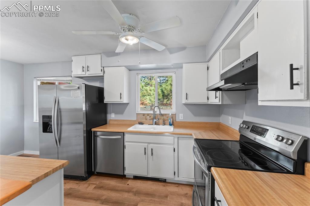 Image 9 of 36: Kitchen featuring stainless steel appliances, butcher block counters, light