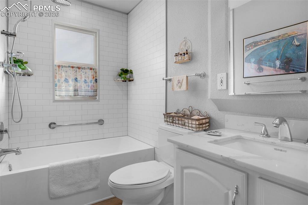 Image 15 of 28: Remodeled Bathroom with a solid surface vanity top, subway tile around the 