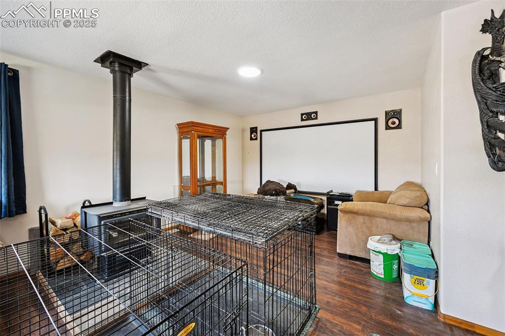 Image 12 of 43: Home theater with dark wood finished floors, a textured ceiling, and a wood