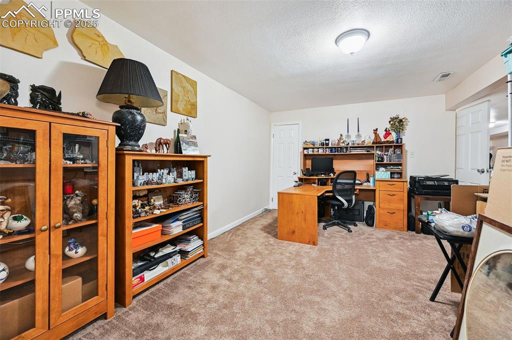 Image 16 of 43: Office space with a textured ceiling and light colored carpet