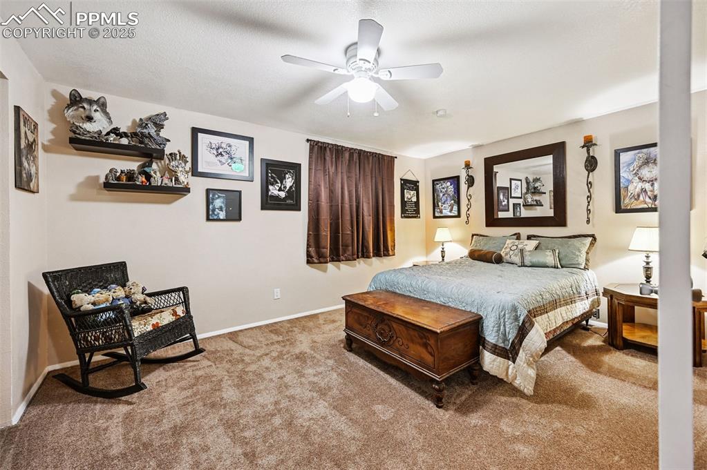 Image 19 of 43: Carpeted bedroom with baseboards and ceiling fan