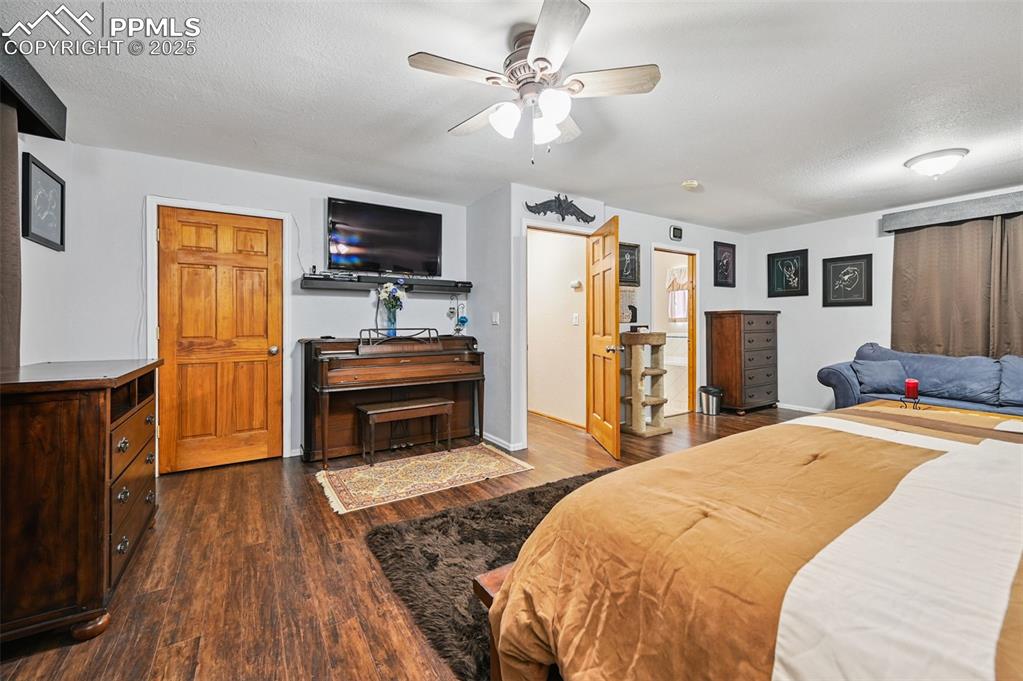 Image 24 of 43: Bedroom featuring dark wood finished floors, ceiling fan, and a textured ce