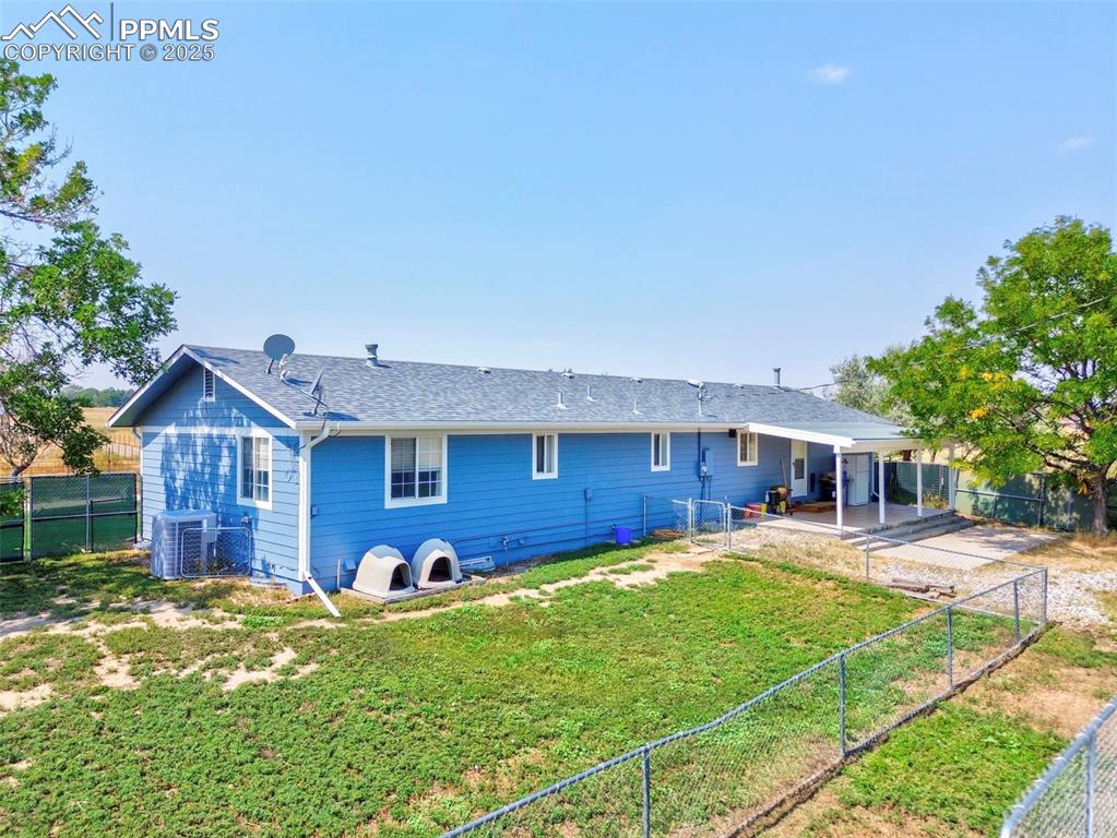 Image 36 of 43: Back of house featuring a fenced backyard, a patio area, and roof with shin