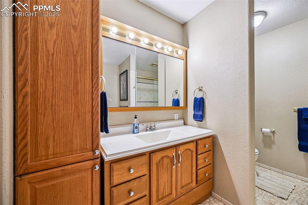 Image 6 of 43: Bathroom featuring a textured wall, vanity, light tile patterned floors, an