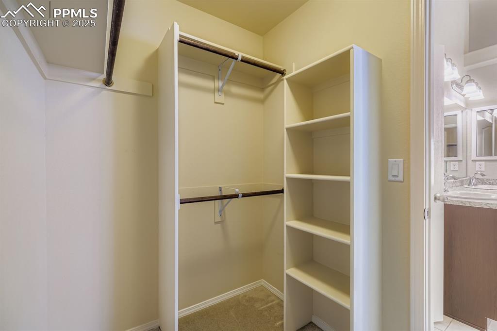 Image 14 of 31: Spacious closet with a sink and light colored carpet