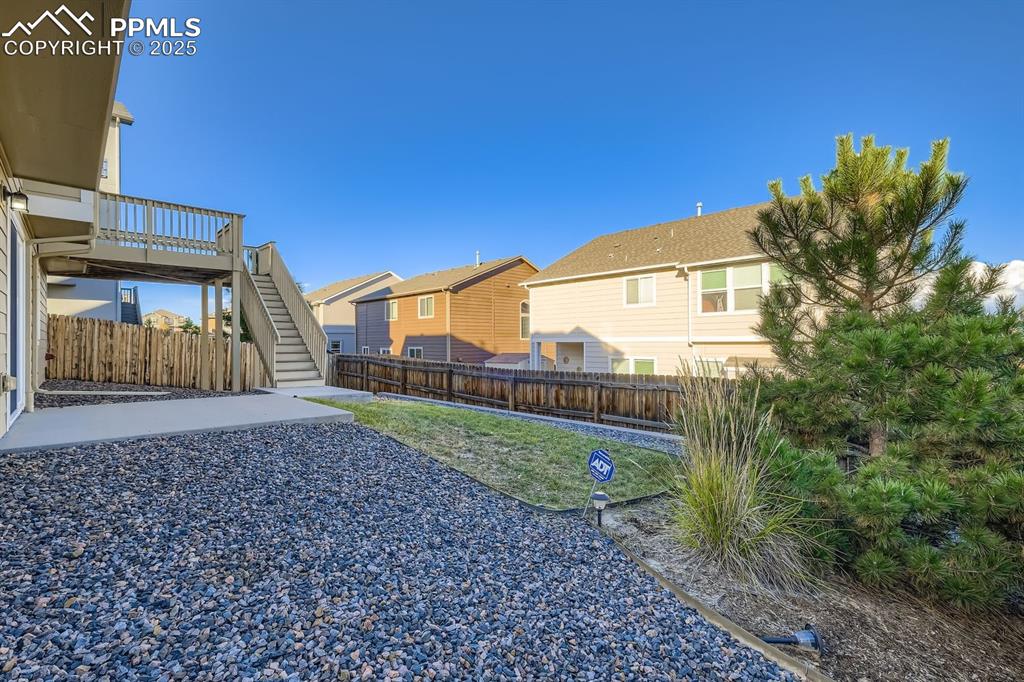 Image 26 of 31: Fenced backyard with a residential view and a wooden deck