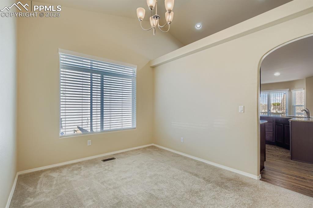Image 9 of 31: Formal dining, vaulted ceiling, a chandelier, and recessed lighting