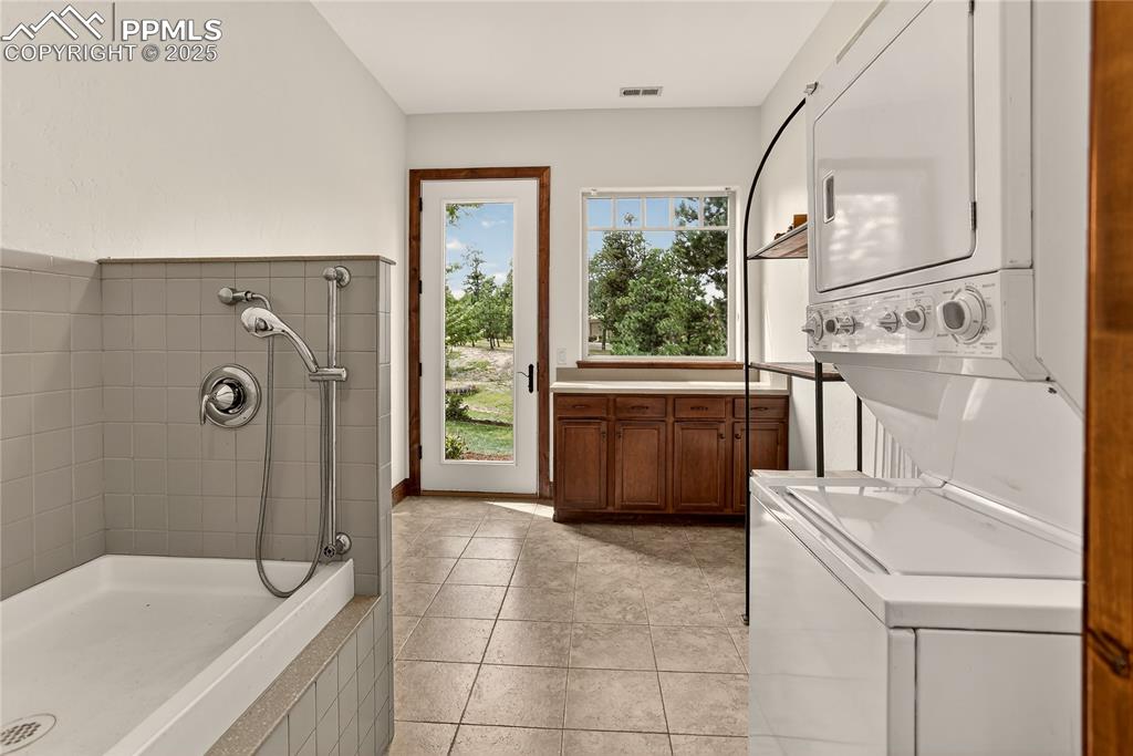 Image 18 of 41: Dog grooming room with exterior access