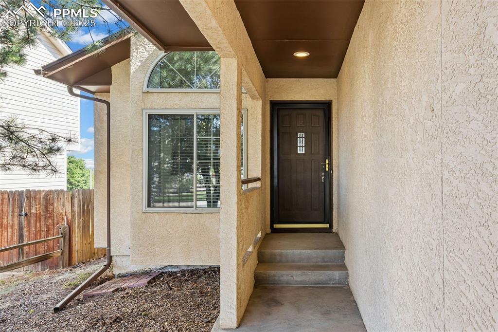 Image 3 of 29: Long covered walkway to front porch and entry into home.