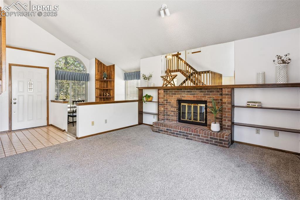 Image 4 of 29: Living room with wood burning brick fireplace.