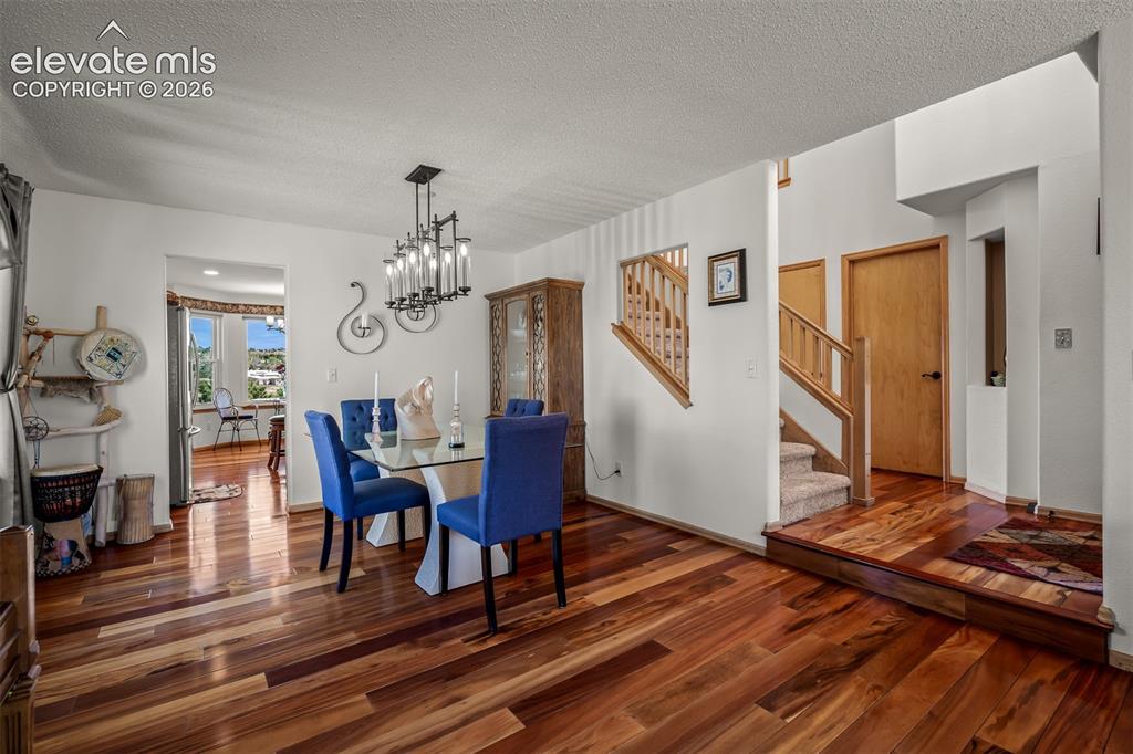 Image 16 of 50: Dining area featuring Brazilian Koa Hardwood flooring, a contemporary chand