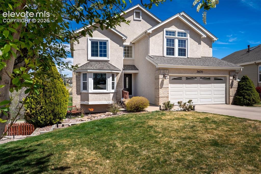 Image 2 of 50: Stucco exterior featuring a two-car garage - Early Spring