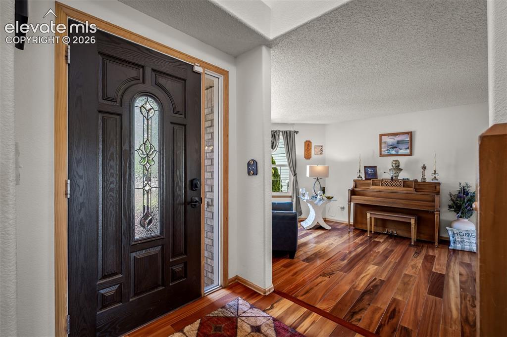 Image 20 of 50: Entryway featuring a dark paneled door with decorative leaded glass.
