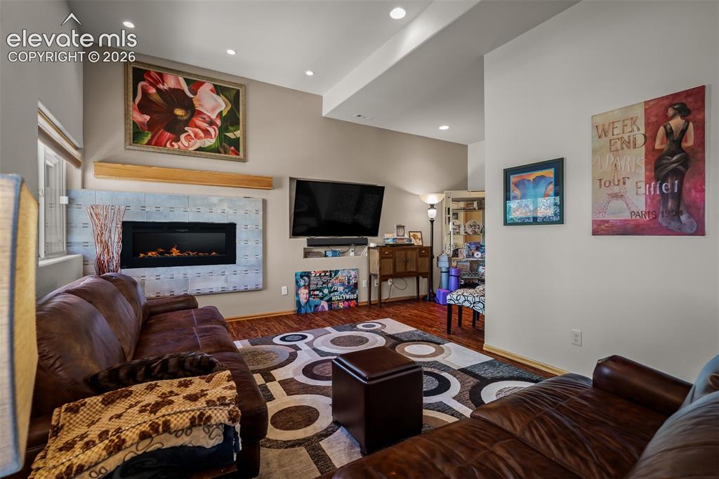Image 37 of 50: Lower level family area featuring wood-finish flooring, recessed lighting,