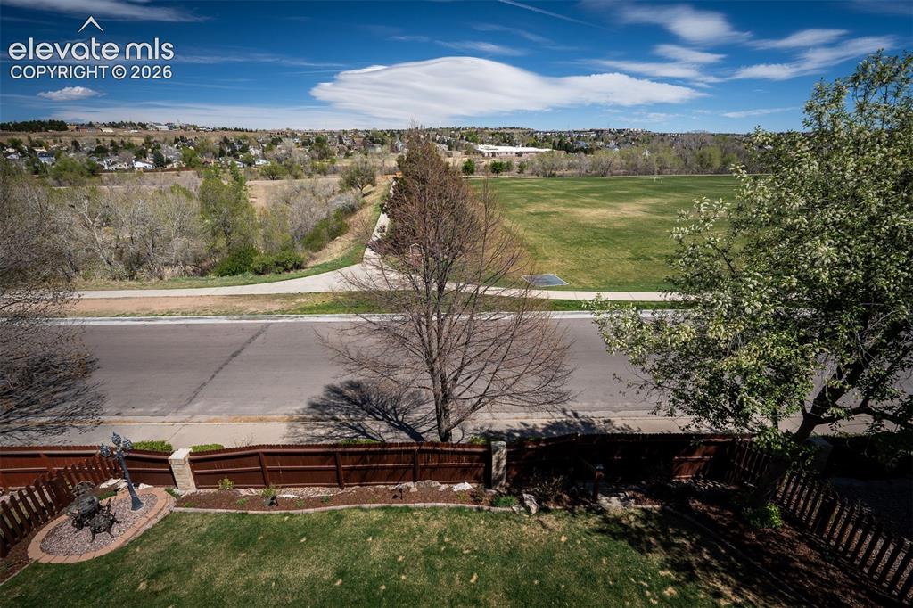 Image 41 of 50: Expansive green space and distant residential areas under a clear sky from 