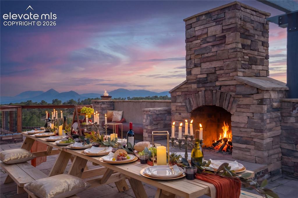 Image 13 of 50: Outdoor stone fireplace with a stone-clad chimney and arched firebox