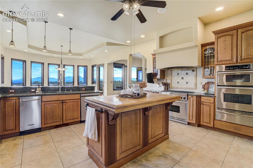 Image 20 of 50: Gourmet kitchen with wood cabinetry, stainless steel appliances, central is