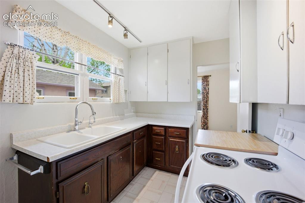 Image 11 of 46: Kitchen featuring a double basin sink with a gooseneck faucet, white counte