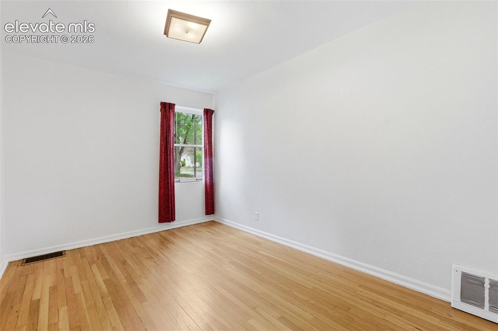 Image 13 of 46: Room featuring wood-finish flooring, a window with natural light, white bas