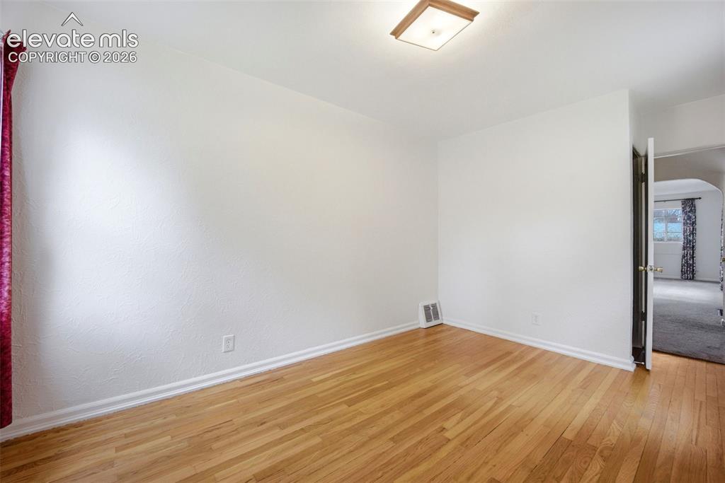 Image 15 of 46: Hardwood flooring throughout, white baseboards, and a flush mount ceiling l