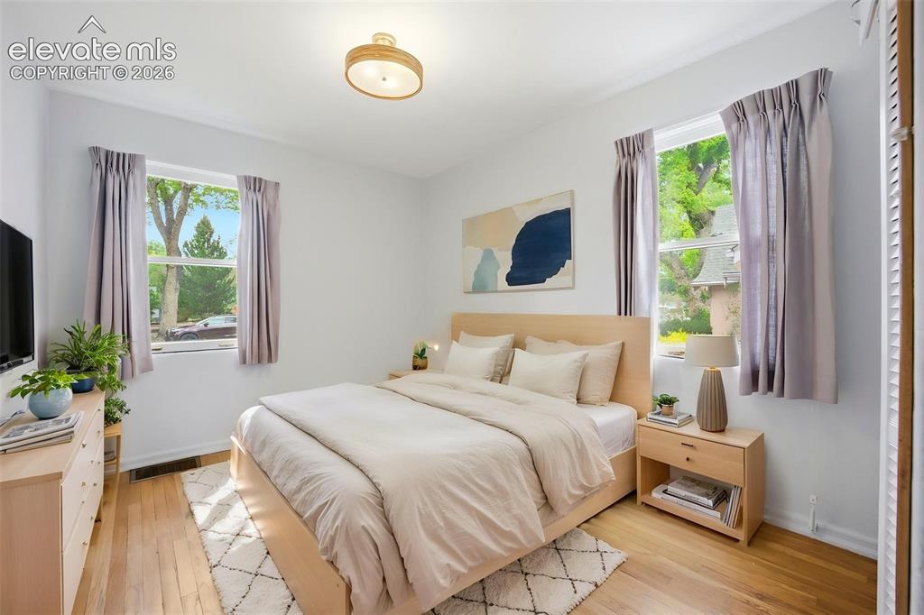 Image 19 of 46: Hardwood flooring throughout, two windows with natural light, neutral wall 