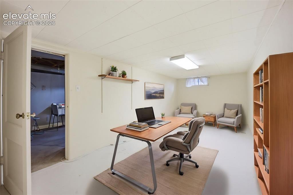 Image 24 of 46: Finished room featuring a drop ceiling, built-in shelving, sconce lighting,