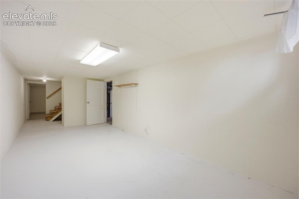 Image 25 of 46: Spacious room with light-toned walls and flooring