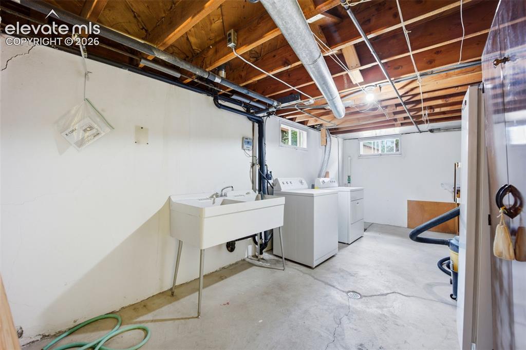 Image 26 of 46: Utility room featuring a large wash sink, concrete flooring, exposed ceilin